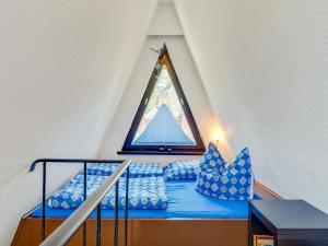 a bed with blue pillows in a attic at A beautiful wooden villa for 12 people in Neubukow