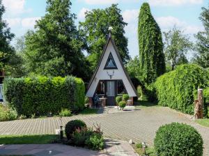 a small house with a triangular roof at A beautiful wooden villa for 12 people in Neubukow