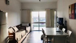 een woonkamer met een tafel en een groot raam bij Lofts en la Sierra!! in Villa Carlos Paz
