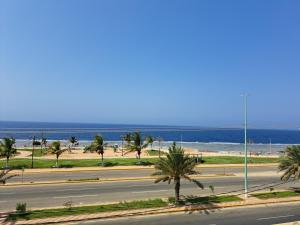 an empty street with palm trees and the beach at فندق ماس الوجه in Al Wajh