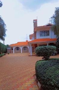 a large house with a brick driveway in front of it at Kathy's Place in Runda in Nairobi