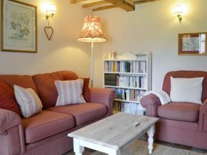 a living room with two couches and a coffee table at Apple Tree Cottage in Foulsham