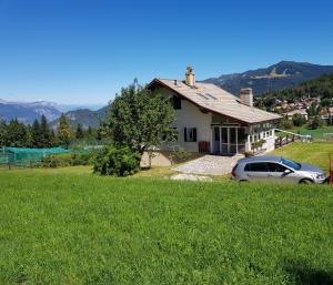 una casa con un coche aparcado en un campo en Chalet Heidi, en Serrada