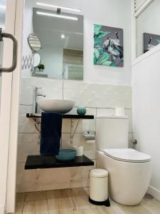 uma casa de banho com um lavatório, um WC e um espelho. em Coqueto apartamento a 50 metros de la playa em Las Palmas de Gran Canaria