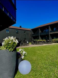 una palla bianca seduta nell'erba accanto a un edificio di Oppdal Gjestetun Hotell a Oppdal