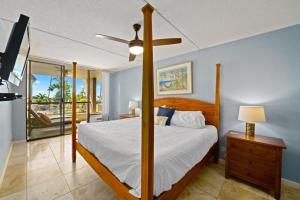 a bedroom with a bed and a ceiling fan at Kona Pacific A206 Condo in Kailua-Kona +11 photos