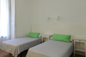 two beds in a room with a blue wall at Hostal La Zona in Madrid