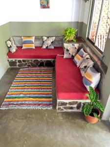 two beds in a room with pillows and blankets at Anam Apartments in Santa Teresa Beach