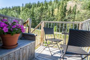 duas cadeiras e um vaso de flores num deque em Downtown Whitehorse Apartment in Old Town em Whitehorse