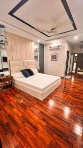 1 dormitorio con 1 cama grande y suelo de madera en Grand Atrium Designer Apartment, en Faisalabad