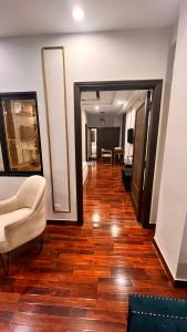 a hallway with a living room with a couch and wooden floors at Grand Atrium Designer Apartment in Faisalabad