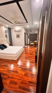 Schlafzimmer mit einem Bett und Holzboden in der Unterkunft Grand Atrium Designer Apartment in Faisalabad