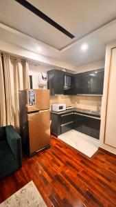 eine Küche mit einem Kühlschrank und Holzböden in der Unterkunft Grand Atrium Designer Apartment in Faisalabad