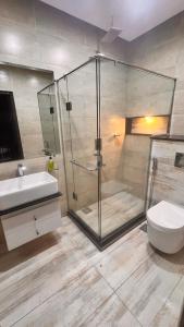 a bathroom with a shower and a toilet and a sink at Grand Atrium Designer Apartment in Faisalabad