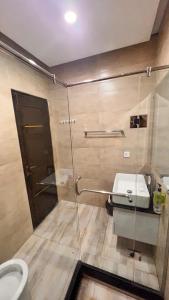 a bathroom with a shower with a toilet and a sink at Grand Atrium Designer Apartment in Faisalabad