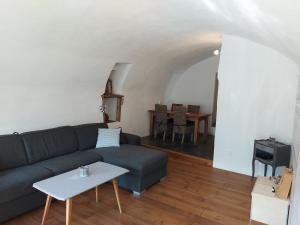 Appartement vouté en Gruyère dans l'Intyamon في Enney: غرفة معيشة مع أريكة وطاولة