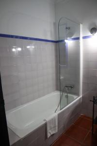 y baño con bañera y ducha acristalada. en Apartamentos Turisticos Casa Cantillo, en Carmona 16 fotos más