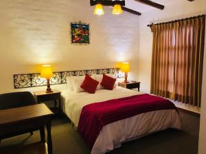 a bedroom with a bed and a desk and two lamps at Hotel el Patio de Monterrey in Huaraz