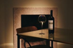 a bottle of wine sitting on a table with a glass at The Vices York in York