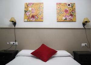 1 dormitorio con 2 camas y 3 pinturas en la pared en Apartamentos Turisticos Casa Cantillo, en Carmona