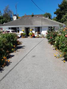a house with flowers in front of a driveway at Saint Martin's Bed and Breakfast in Bandon
