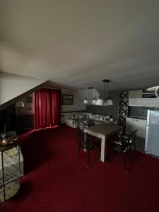 a living room with a table and chairs and a red carpet at -- Milmari President apartments -- in Kopaonik