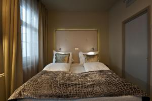 ein großes Bett in einem Zimmer mit einem großen Fenster in der Unterkunft Clarion Collection Hotel Folketeateret in Oslo