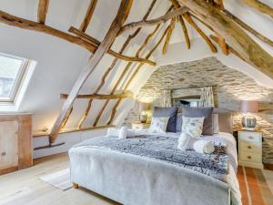 1 dormitorio con 1 cama grande con vigas de madera en The Threshing Barn - Hssw, en East Down