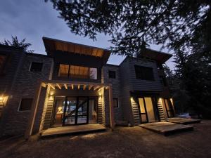 a house with the front doors lit up at night at Hygge Haus in Villa La Angostura