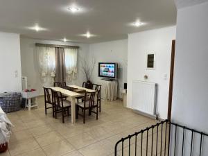 a dining room and living room with a table and chairs at Apartment in Salamina with Garden & Sea view in Selínia