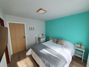 - une chambre avec un lit et un mur bleu dans l'établissement Hygge Haus, à Villa La Angostura