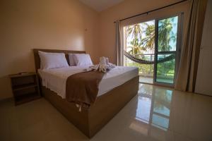 1 dormitorio con 1 cama grande y ventana grande en Pousada dos Corais, en Mundaú