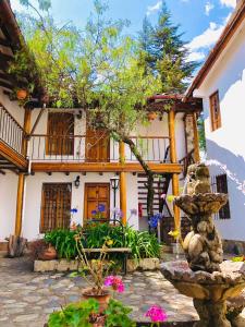 a house with a courtyard with flowers and a fountain at Hotel el Patio de Monterrey in Huaraz
