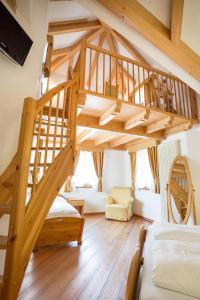 a wooden spiral staircase in a room with a bedroom at Hotel Fior Di Bosco in Giovo