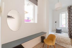 ein Schlafzimmer mit einem Spiegel, einem Bett und einem Stuhl in der Unterkunft COLOSSEO con il CUORE in Rom