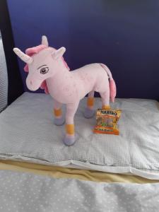 a pink toy horse on a bed with a box at Baumann's apartment - ruhige Lage in Grifte