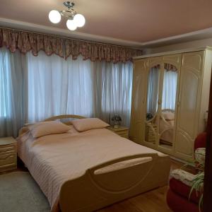 um quarto com uma cama com lençóis brancos e janelas em Лаванда em Yaremche