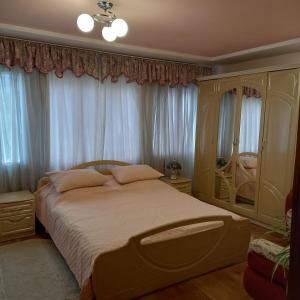 um quarto com uma cama grande em frente às janelas em Лаванда em Yaremche
