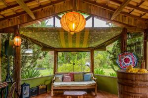 a living room with a couch and a large window at Pousada Mandala das Águas in Aiuruoca