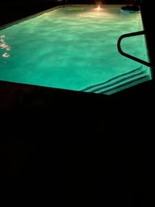 a swimming pool with green water in a dark room at Private Oasis Condo with River views across from Laughlin in Bullhead City