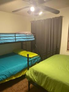 a bedroom with two bunk beds and a ceiling fan at Private Oasis Condo with River views across from Laughlin in Bullhead City