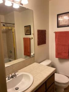 y baño con lavabo, aseo y espejo. en Private Oasis Condo with River views across from Laughlin en Bullhead City