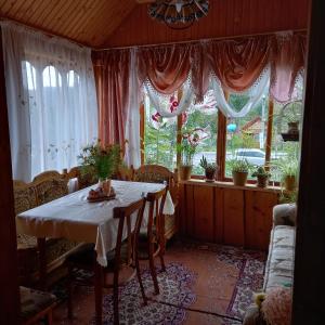 uma sala de jantar com uma mesa e algumas janelas em Лаванда em Yaremche