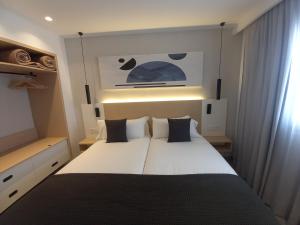 a bedroom with a large white bed in a room at Apartamentos Marivista in Playa del Ingles