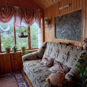 uma sala de estar com um sofá e duas janelas em Лаванда em Yaremche