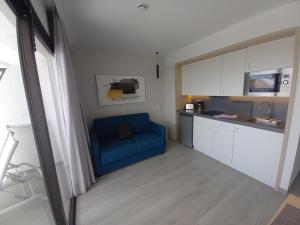 a living room with a blue couch in a kitchen at Apartamentos Marivista in Playa del Ingles