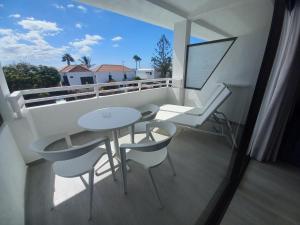 balcón con mesa, sillas y ventana en Apartamentos Marivista, en Playa del Inglés