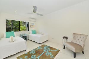 a living room with a bed and a chair at Sea La Villa Port Douglas in Port Douglas +8 photos