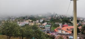 a view of a city from a hill with houses at RC HOMESTAY in Kodaikānāl
