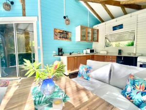 ein Wohnzimmer mit einem Sofa und einem Tisch in der Unterkunft Villa Gaïa - Bungalow Ti-Spa et son jacuzzi privé dans un jardin tropical, séjour en amoureux ou en famille in Le Diamant